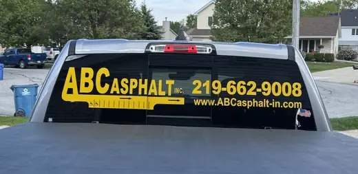 Pickup rear window with business lettering and a phone number
