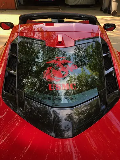 Red sports car rear window with a printed graphic