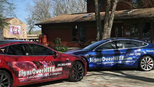 Two wrapped cars parked in front of a house